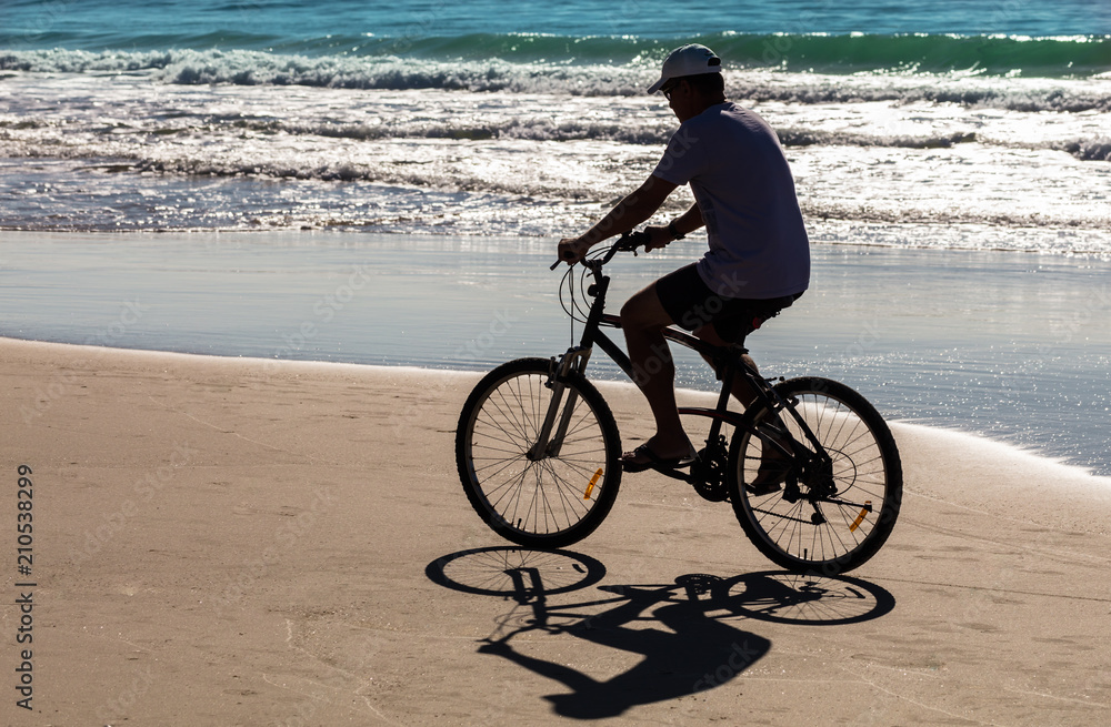 Fototapeta premium Silhueta de ciclista na praia