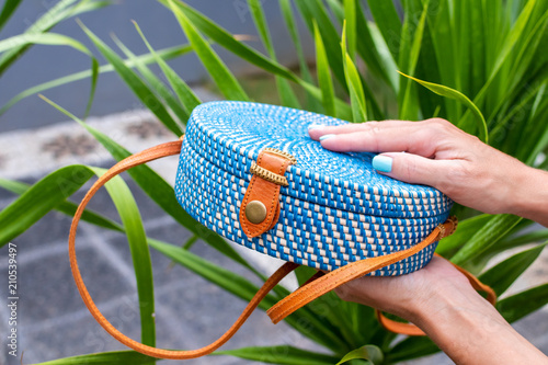 Fashionable stylish rattan bag on a tropical background. Tropical island of Bali, Indonesia. Rattan handbag. photo