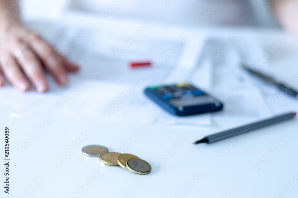 Fototapeta premium Oberfläche eines Schreibtischs mit Münzgeld, Stift und Taschenrechner in einem Bürogebäude