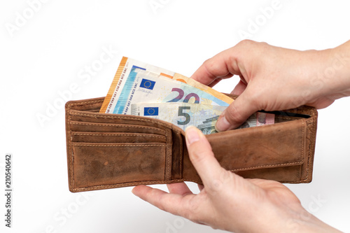 Two hands of a woman counting euro banknotes in a leather purse