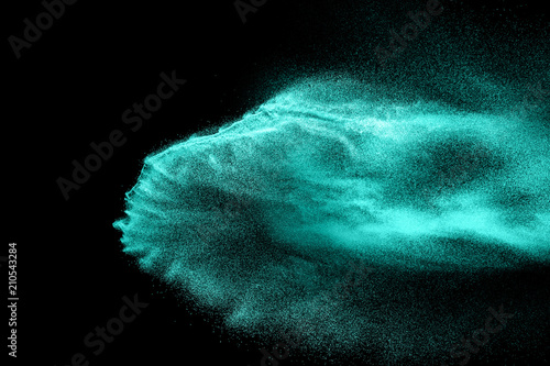 Green sand explosion isolated on black background. Abstract sand cloud. Green sand splash against on dark background. Sandy fly wave in the air.