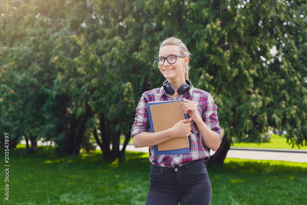 Fototapeta premium Student girl with books in park outdoors