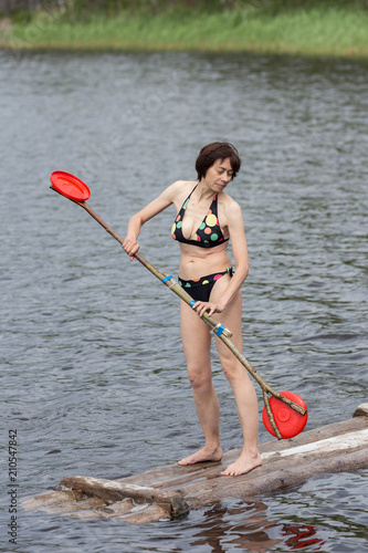 woman stands on a wooden raft