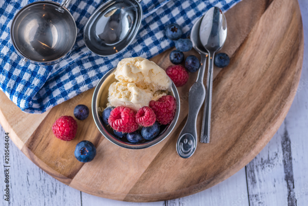 custom made wallpaper toronto digitalA scoop of vanilla ice cream with raspberries and blueberries on a wooden board and blue and white dish towel.
