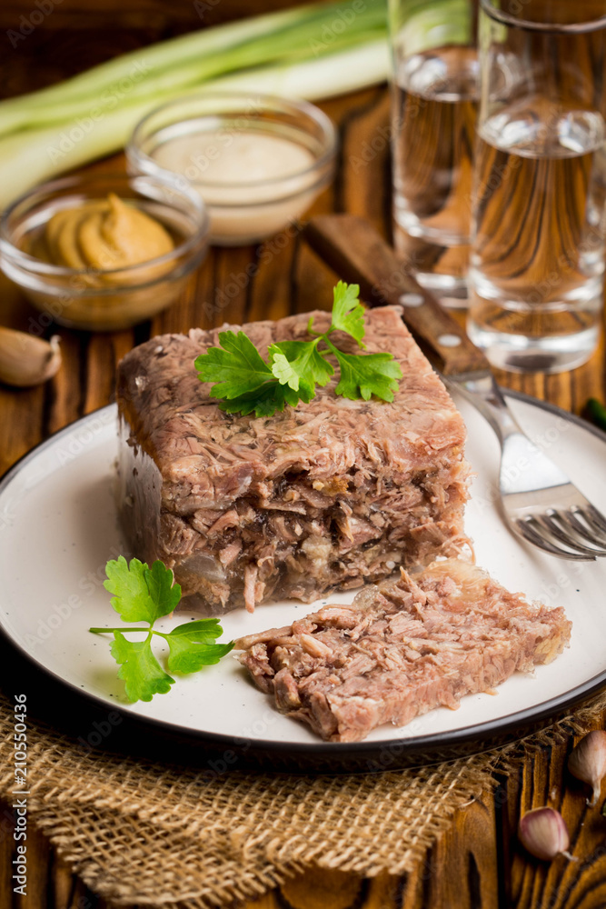 Jelly with meat, beef aspic, traditional Russian dish, portion on plate, mustard and horseradish