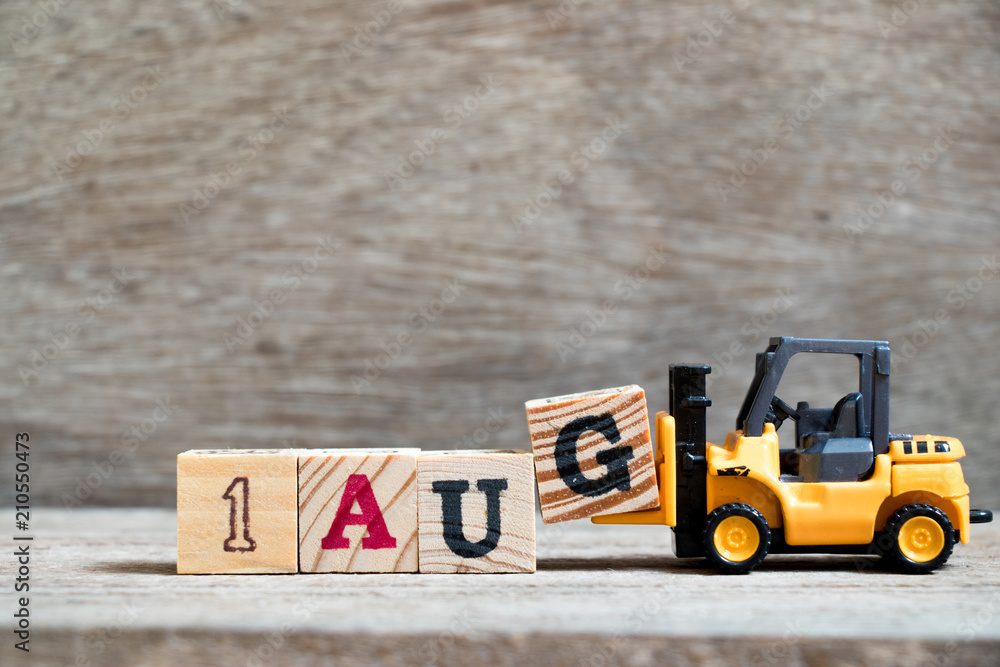 Toy forklift hold block G to complete word 1 aug on wood background (Concept for calendar date in month August) - obrazy, fototapety, plakaty 
