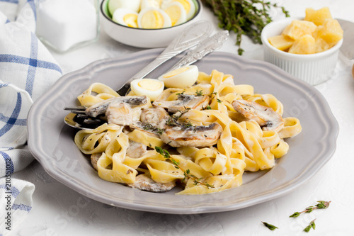 Italian pasta tagliatelle with mushroom cream sauce, cheese and thyme tasty homemade dinner