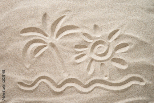 Sun, palm and sea hand-drawn on the beach sand