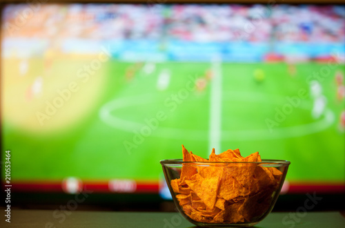 beer glasses and chips in front of tv - watching world cup football at home - soccer supporters