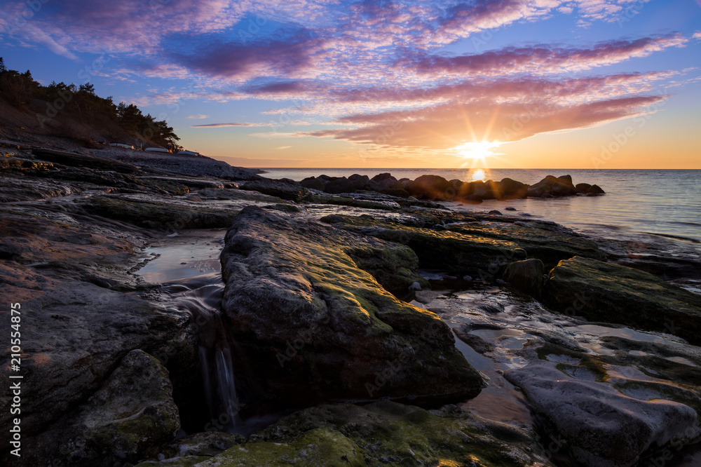 Obraz premium Stones waterfall and cliffs at the sea