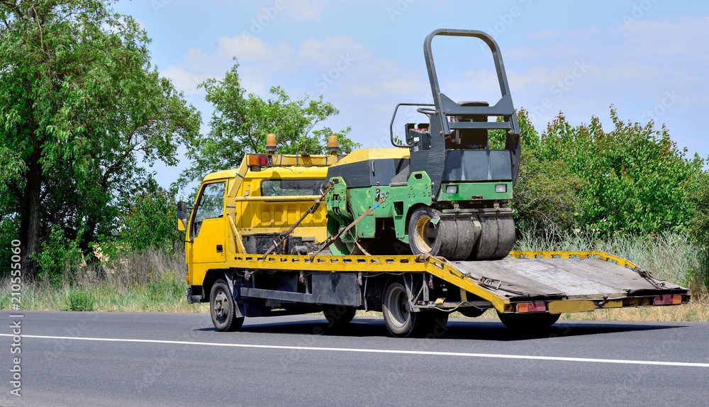 Ukraine, Odessa. June 15, 2018. The route Odessa - Nikolaev. Tow truck and asphalt roller on the city road.