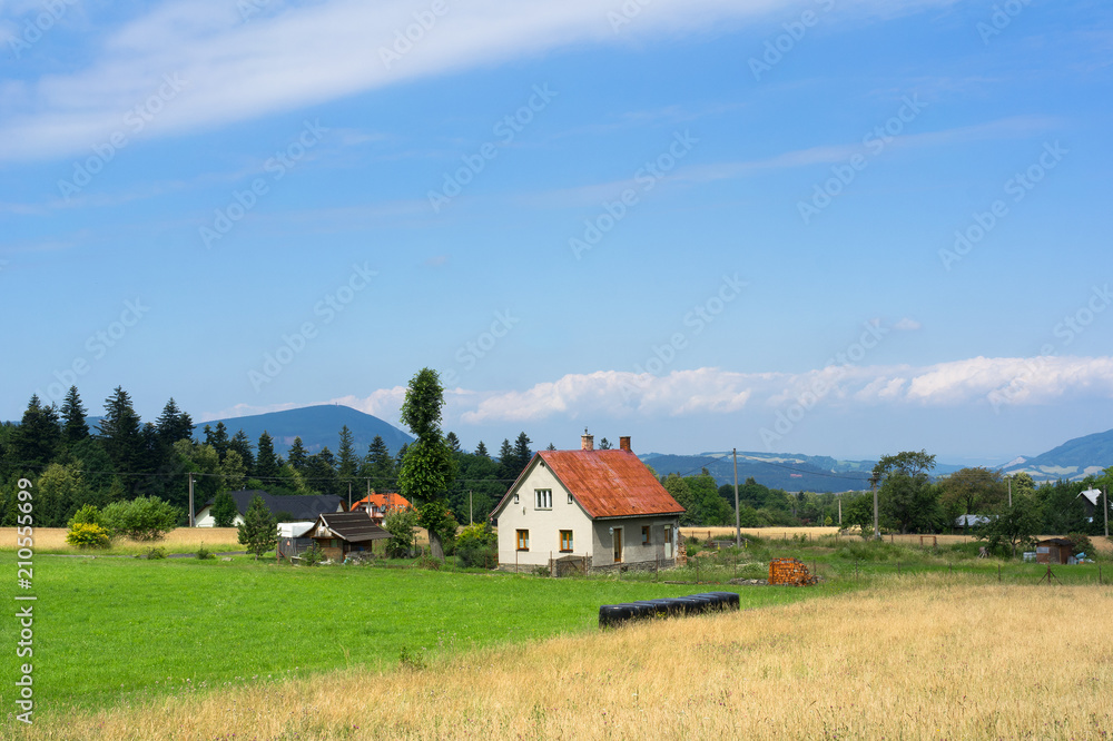 Cottage in the countryside. Authentic village in Czech Republic. Beskid mountains in the distance. 