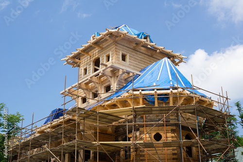 Libusin, Pustevny - Copy of old building is constructed and reconstructed. Construction, reconstruction and restoration of historical architecture. Wooden logs, scaffolding photo