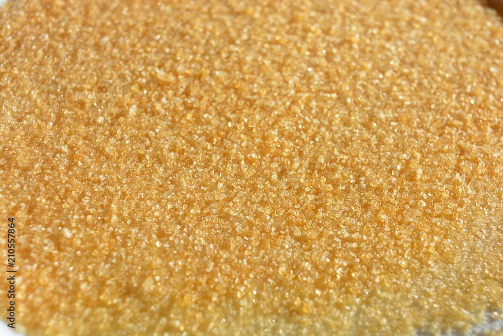 On a white glass plate in the light of the sun, poured natural pear gelatin for the preparation of fruit jelly in the form of loose yellow crutches On a white glass plate in the light of the sun, poured natural pear gelatin for the preparation of fruit jelly in the form of loose yellow crutches