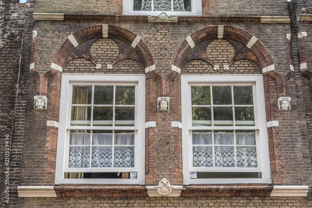 Traditional  Dutch white lace curtains behind two ancient windows