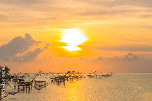 golden sky above fishing trap in Pak Pra Talay Noi sea Phatthalung south of Thailand photo