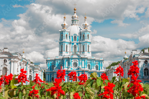 Smolny Cathedral Saint-Petersburg and growing red flowers in the foreground. photo