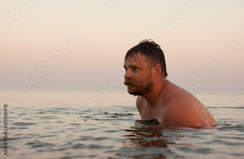 mustachioed bearded man swims into the sea