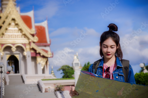A girl's traveler with a look and see the map. In the Thai temple. And see the beautiful culture. © aboutnuylove