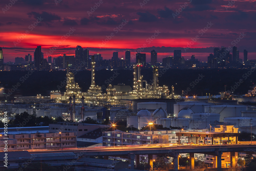 A night landscape view of city and Oil refinery industry under colorful sky at sunset time