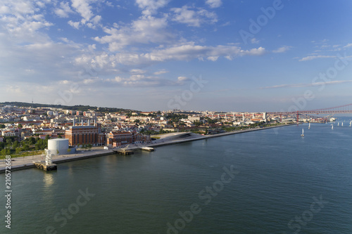 Aerial view of the city of Lisbon with sail boats on the Tagus River and the 25 of April Bridge on the background  Concept for travel in Portugal and visit Lisbon © Tiago Fernandez
