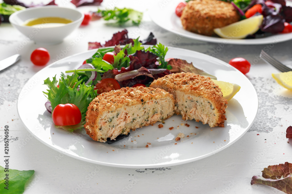 Home made Fish Cake salmon, spinach and potato. served on plate with vegetables Home made Fish Cake salmon, spinach and potato. served on plate with vegetables