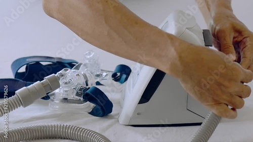 Cpap installation . Man hands assembling patient tube to cpap mask and cpap machine  in white background, hd video selective focus.