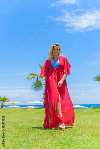 Luxury Resort. Woman Relaxing at sea. Beautiful Happy Healthy Female Model Enjoying Summer Travel Vacation  Looking At Sea View. Summertime Recreation  Relax And Spa Concept 