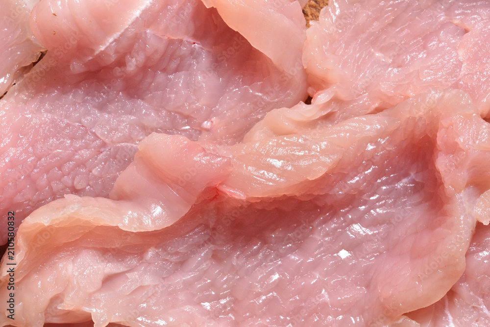 Raw and sliced turkey meat. Fresh pink turkey meat, close-up Raw and sliced turkey meat. Fresh pink turkey meat, close-up