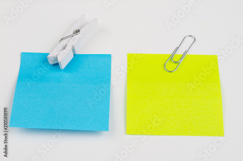 Blank colored sticky notes with clips. Office accessories for listing and memorizing on the table. White background.