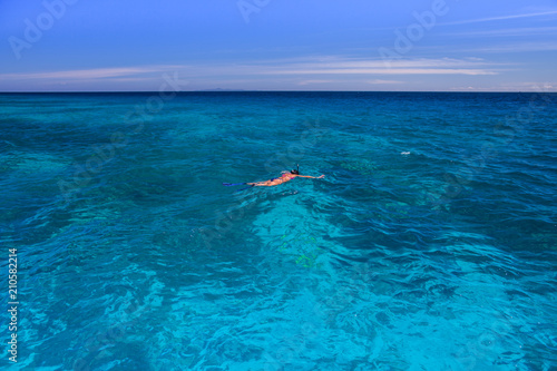 Clear wave of sea and people is swimming with snorkel with background of mountain under clear sky at ocean in Tropicana located south of thailand
