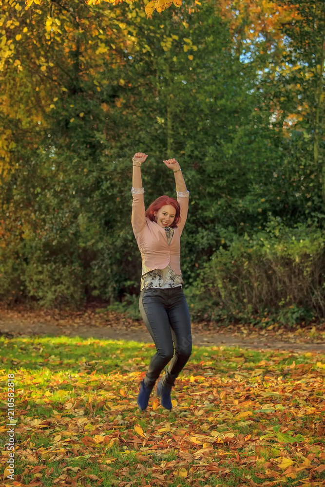 Happy young woman jumping in autumn park Happy young woman jumping in autumn park