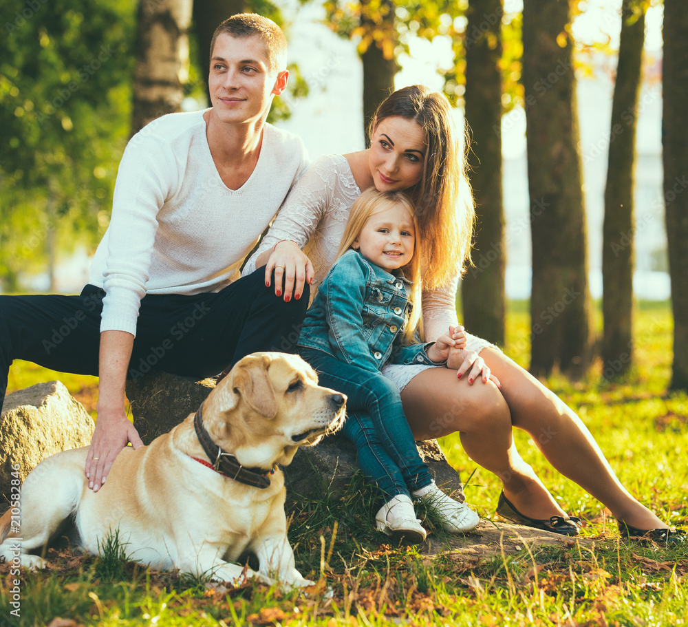 Happy family with their dog in the park on a sunny day Happy family with their dog in the park on a sunny day
