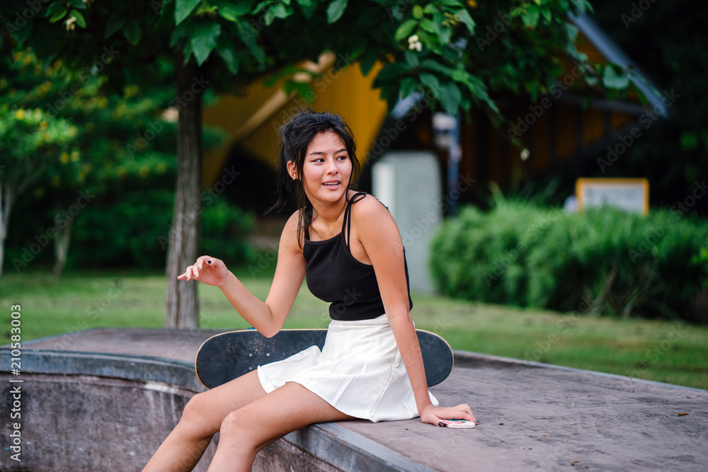 A portrait of a cute, cool, and attractive skater girl sitting with poise in the skater park. A portrait of a cute, cool, and attractive skater girl sitting with poise in the skater park.
