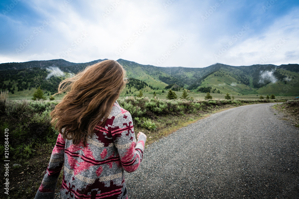 Woman walking or hiking in the mountains long hair 