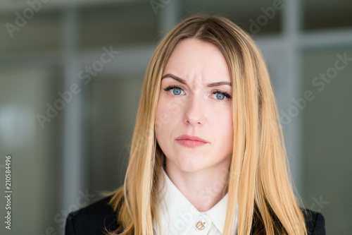 emotion face. woman with a quizzical interrogatory inquiring look. business lady at office workspace. young beautiful blond girl portrait