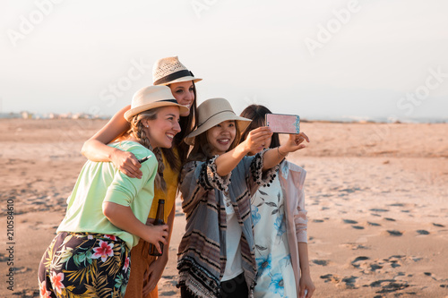 Happy multiracial young people are making a selfie at the beach while they are in a summer party. Friends and holiday concept