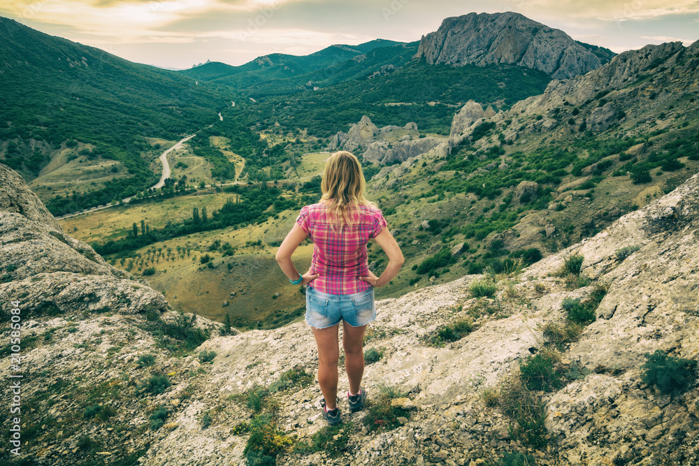Naklejka premium Girl standing on the edge of the cliff