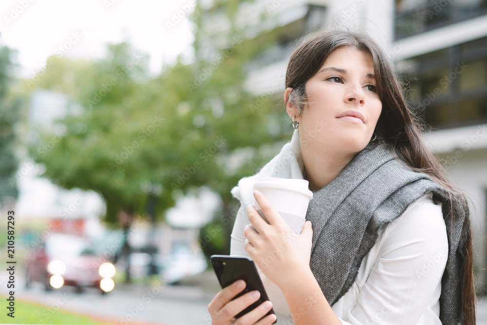 Young latin woman with her mobile phone and cup of coffee Young latin woman with her mobile phone and cup of coffee