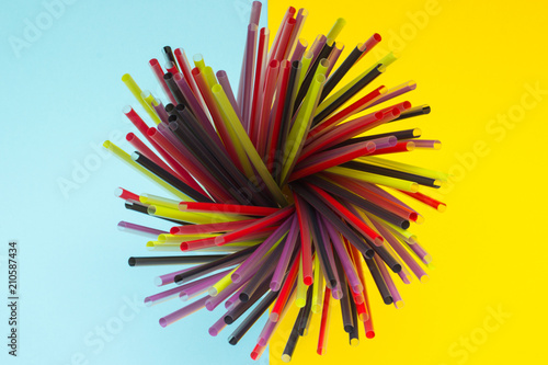 colorful straw on a blue and yellow background top view