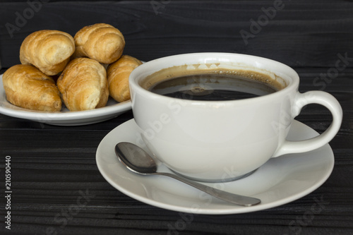 coffee with foam and croissants on a dark background