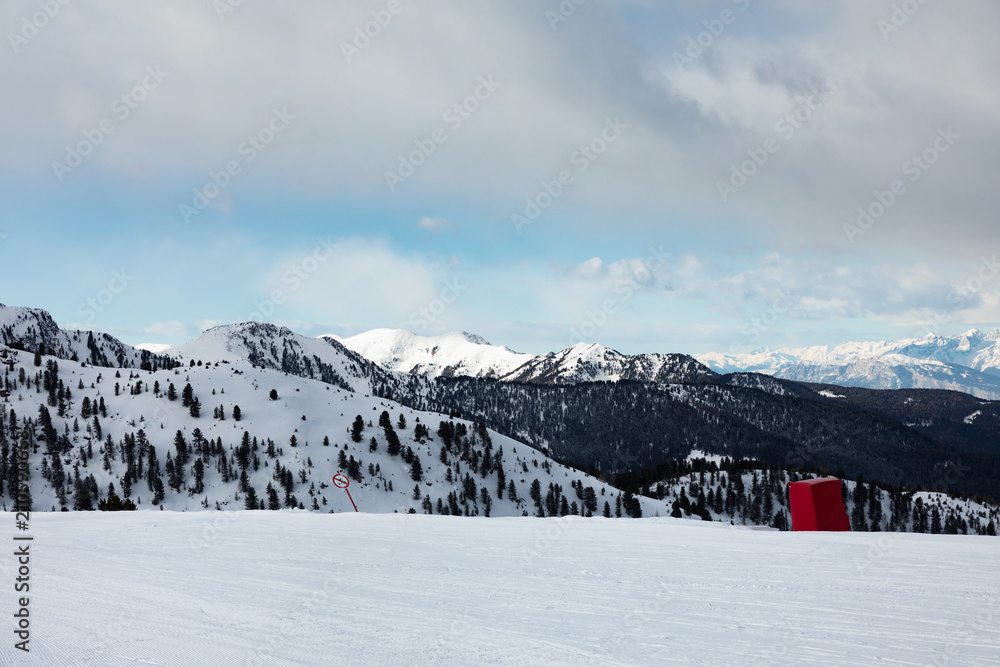 Snowy mountain peaks in the Dolomites.. Empty ski slope in winter on a sunny day. Prepare ski slope, Alpe Cermis, Italy