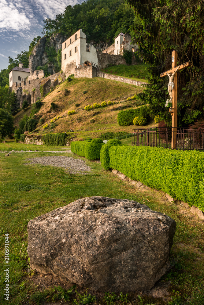 Skalka nad Vahom. An ancient church in a rock hill with a green background made by forest.