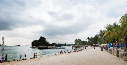 Tourists have a rest and swim at Siloso Beach, Sentosa Island, Singapore. People relaxing on paradise beach