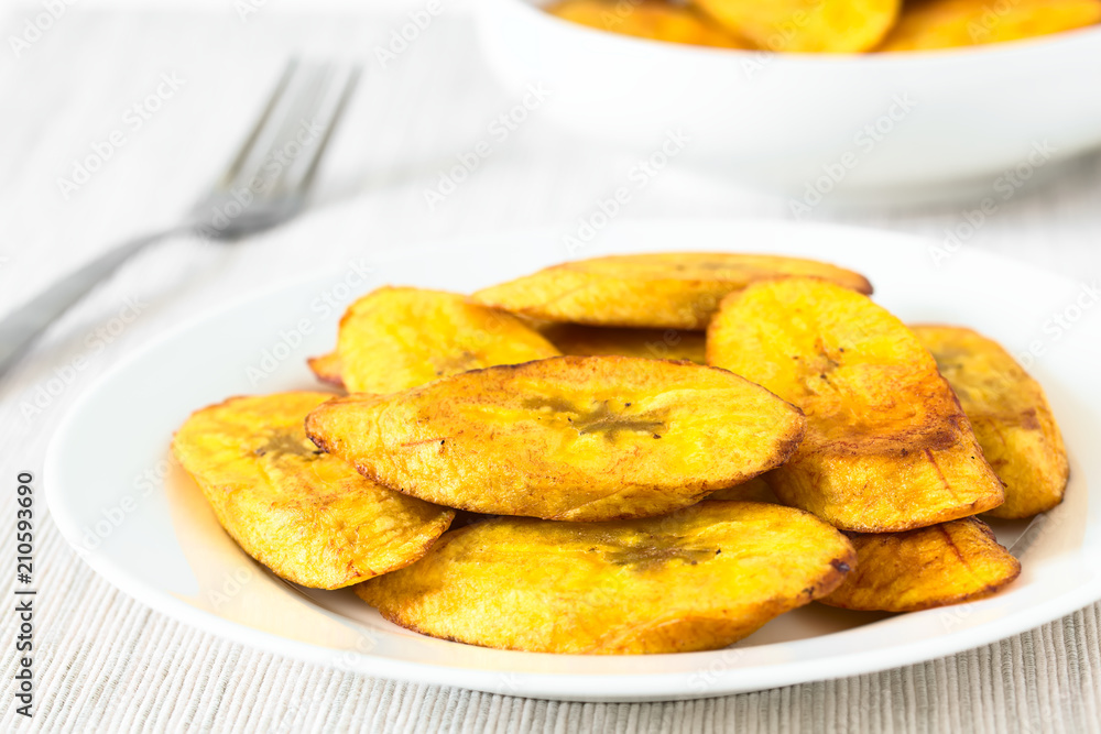 Fried slices of ripe plantains traditional snack and accompaniment in Latin America, photographed with natural light (Selective Focus on the front of the top slice) Fried slices of ripe plantains traditional snack and accompaniment in Latin America, photographed with natural light (Selective Focus on the front of the top slice)