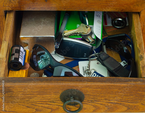 messy cabinet drawer with keys and glasses photo