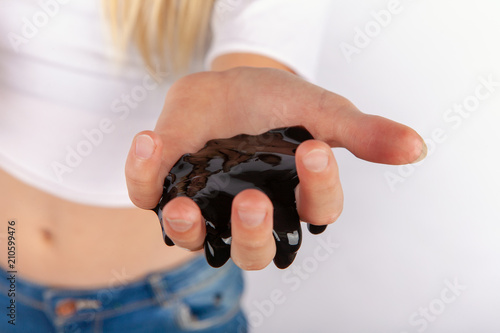 Young girl’s hand holding black slime