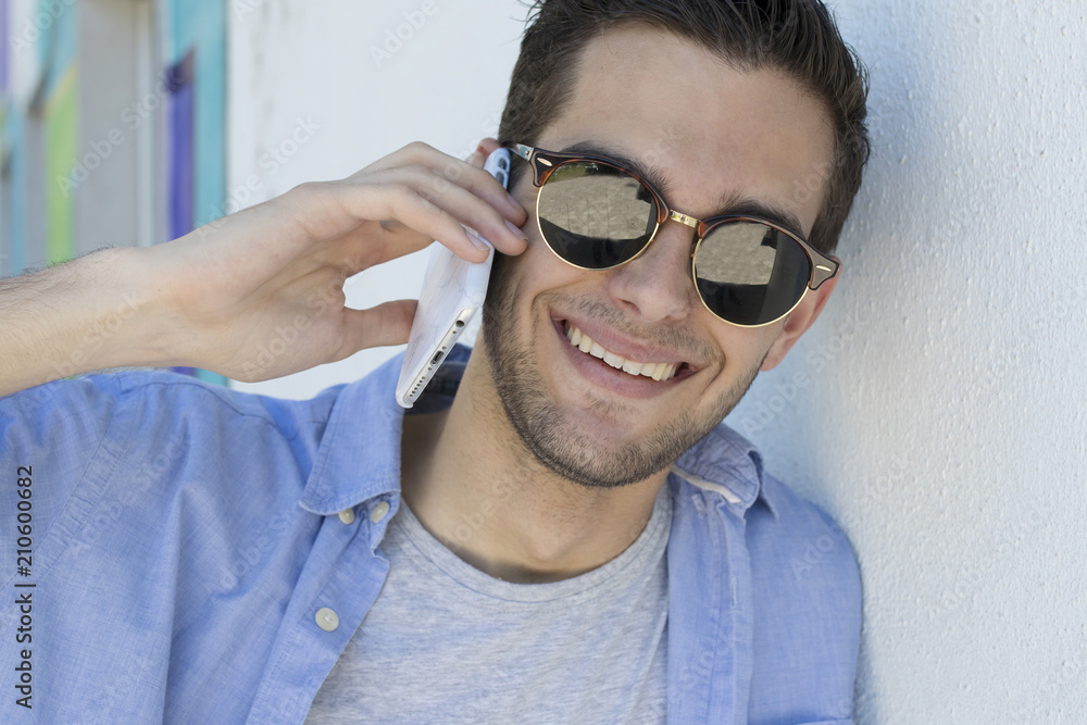 portrait of young with sunglasses talking on mobile phone portrait of young with sunglasses talking on mobile phone