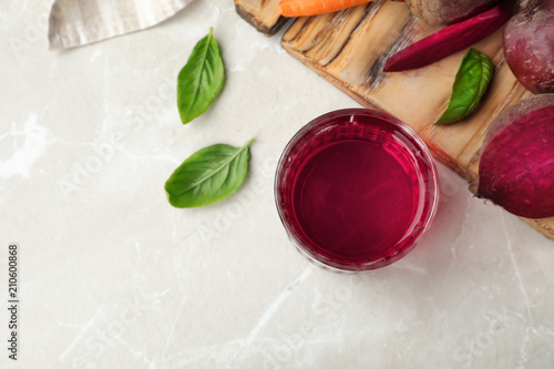 Glass with fresh beet juice and ingredients on table, top view