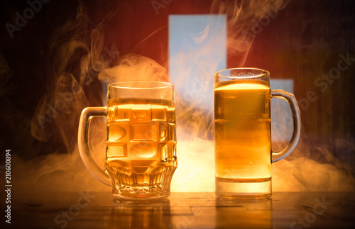 Creative concept. Beer glasses on table at dark toned foggy background with blurred view of flag of Switzerland. Support your country with beer concept.